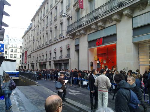 Longue queue de gens (de filles) devant H&M pour acheter des chaussures Jimmy Choo chez H&M.'